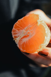 Close-up of hand holding orange