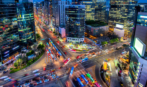 High angle view of vehicles on road in illuminated city at night