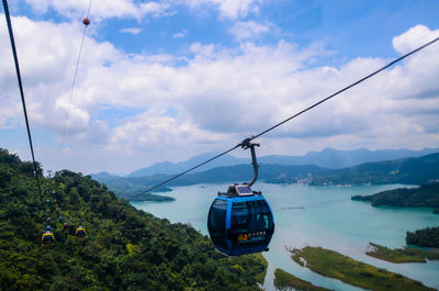 Overhead cable car over sea against sky