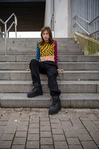 Portrait of young woman sitting on staircase