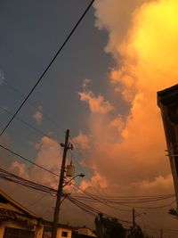 Low angle view of silhouette electricity pylon against sky during sunset