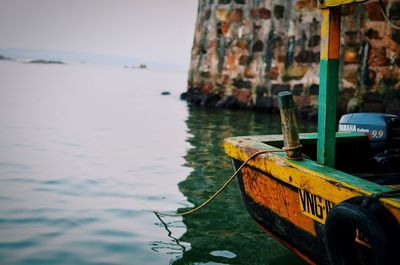 Fishing boat moored on sea against sky