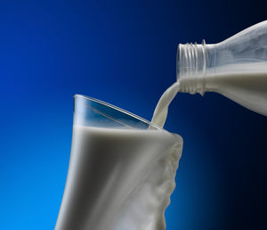 Close-up of drink glass against blue background