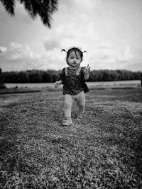 Girl standing on field against sky