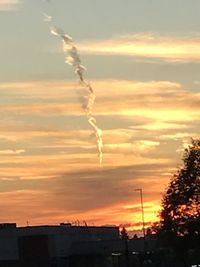 Low angle view of vapor trails in sky during sunset