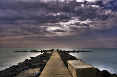 Pier over sea against sky during sunset