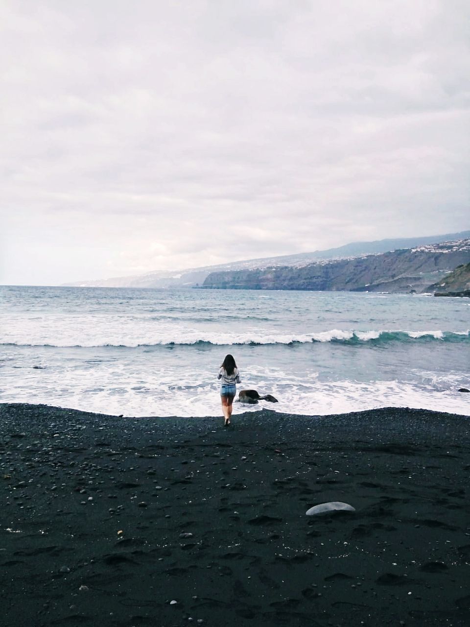 sea, water, sky, beauty in nature, real people, leisure activity, land, beach, scenics - nature, one person, rear view, horizon, lifestyles, horizon over water, nature, cloud - sky, day, tranquility, outdoors, looking at view