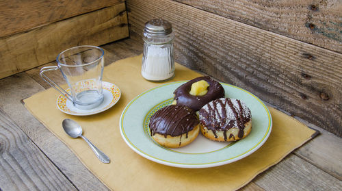 High angle view of chocolate donuts in plate on table