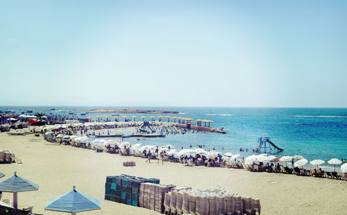 Panoramic view of people on beach against clear sky