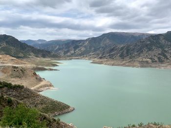 High angle view of lake and mountains against sky