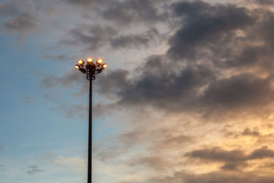 Low angle view of illuminated street light against sky