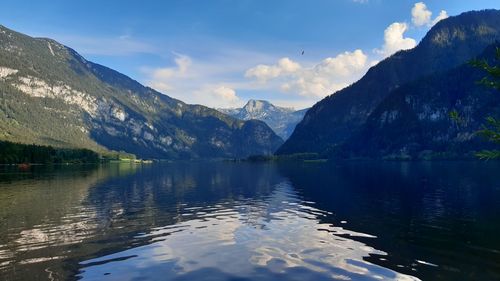 Scenic view of lake by mountains against sky