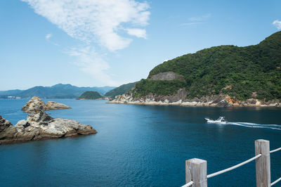 Small boats navigating along the sea cliffs of izu, japan