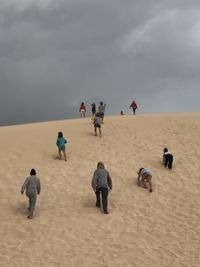 People at beach against sky