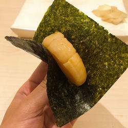 Close-up of hand holding uni sushi ,japan food