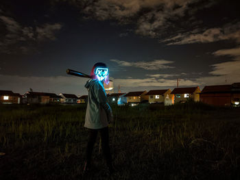 Man standing on field against sky at night