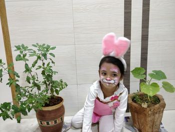 Portrait of cute girl in pink potted plant