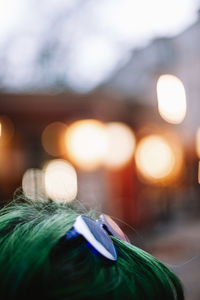 Close up of purple sunglasses on green haired head