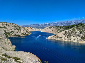 High angle view of river amidst mountains against clear blue sky