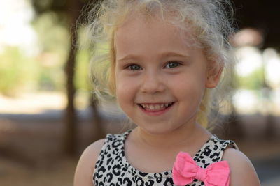 Close-up portrait of girl smiling while standing outdoors