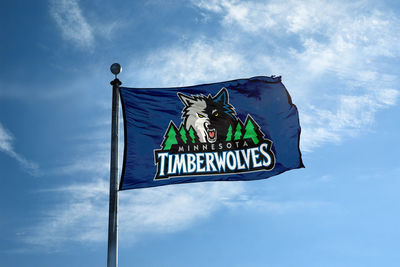 Low angle view of sign board against blue sky