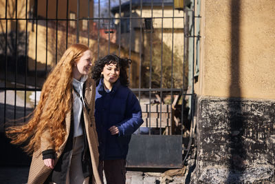 Female friends walking together ourdoors on walkway in city