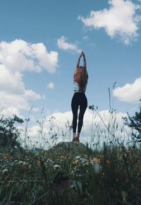 Woman standing on field against sky