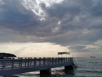 Pier over sea against sky during sunset