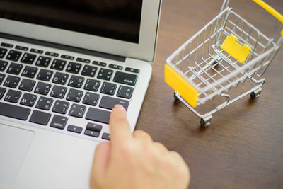 Close-up of person using laptop on table