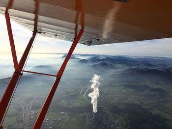 Airplane flying over snowcapped mountain against sky