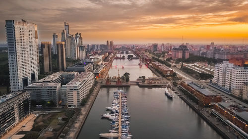 High angle view of river amidst buildings against sky during sunset