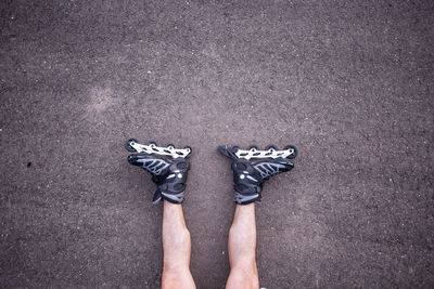 Low section of man with roller skates lying on floor