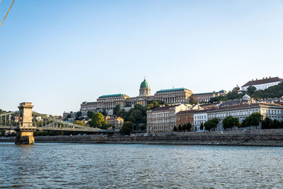 Bridge over river by buildings in city