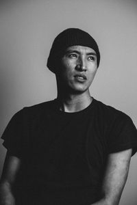 Portrait of young man standing against wall