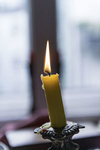 Close-up of lit candle at home