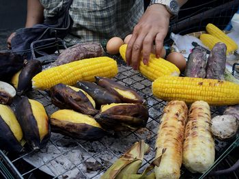 Person baking corn and sweet potato