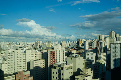 View of cityscape against cloudy sky