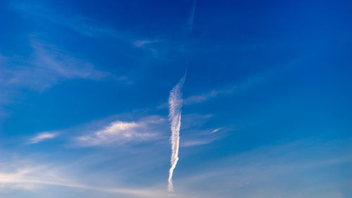 Low angle view of vapor trail in blue sky