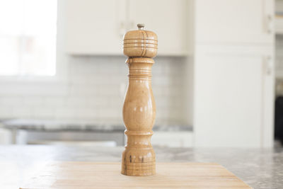 Close-up of wooden pepper mill on kitchen counter