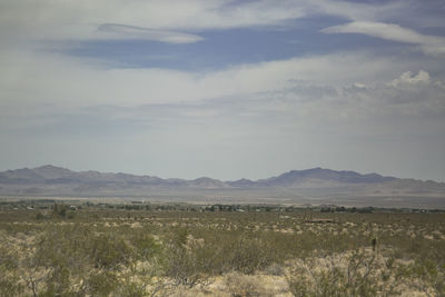 Scenic view of field and mountains against sky