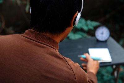 Rear view of man using mobile phone