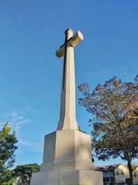 Low angle view of cross against blue sky