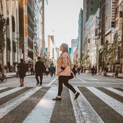 Woman walking on zebra crossing in city