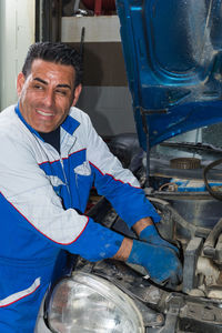 Smiling man repairing car