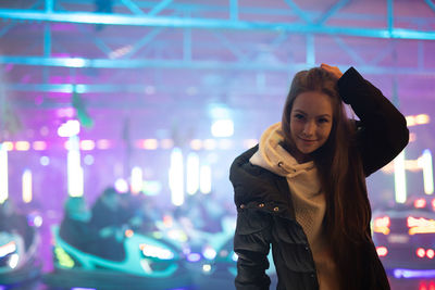 Portrait of woman standing against illuminated lights