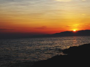 Scenic view of sea against orange sky