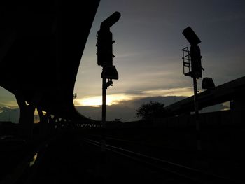 Silhouette of railroad station against sky at night