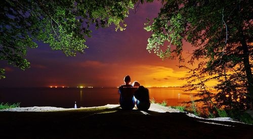 Man standing on sea against sky at night