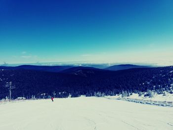 Scenic view of landscape against clear blue sky during winter