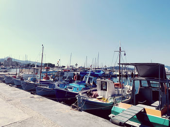 Sailboats moored at harbor against clear blue sky